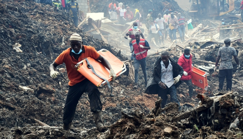 Des volontaires cherchent les corps des résidents tués par un glissement de terrain à la décharge de Kiteezi, dans les faubourgs de Kampala, le 10 août 2024.