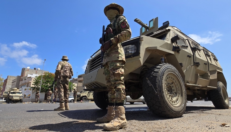 Les forces de sécurité libyennes surveillent un point de contrôle à Tripoli, le 13 mai 2025.