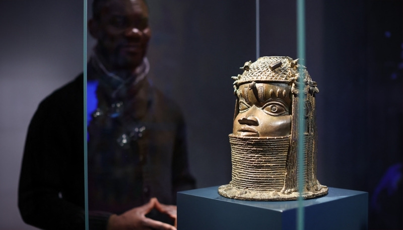 L'artiste nigérian Enotie Paul Ogbebor à côté d'un bronze béninois au Grassi Museum für Völkerkunde de Leipzig.