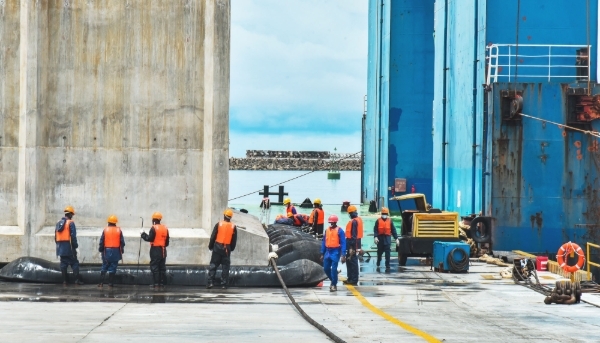 Techniciens travaillant à l'installation du premier caisson de la phase II de la construction du port en eau profonde de Kribi, au Cameroun, en octobre 2022.