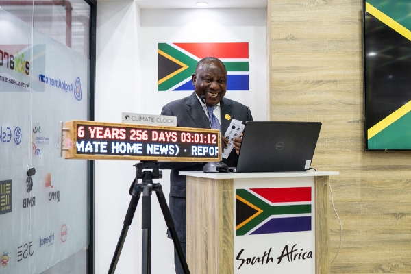 Le président sud-africain Cyril Ramaphosa pose à côté de l'horloge du climat lors de la COP27 à Charm el-Cheikh, le 17 novembre 2022.